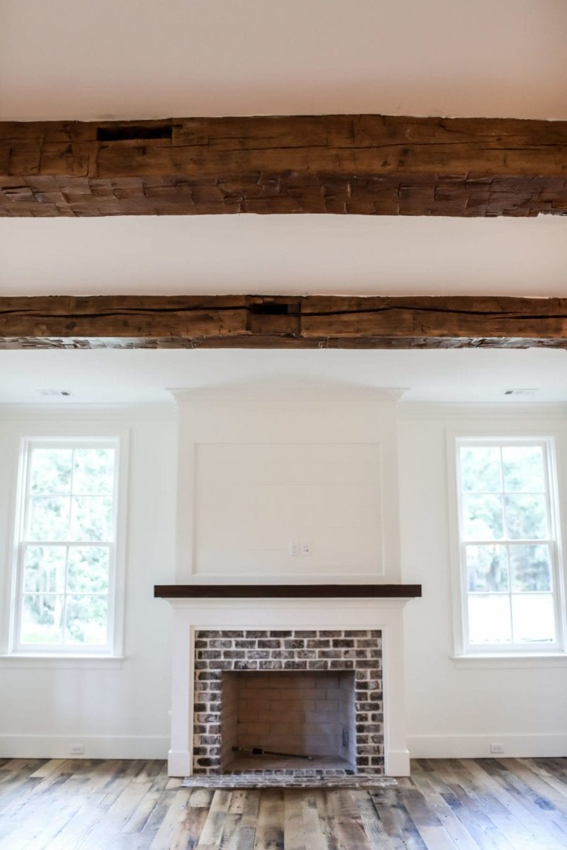 wood burning fireplace in keeping room with exposed wood beams