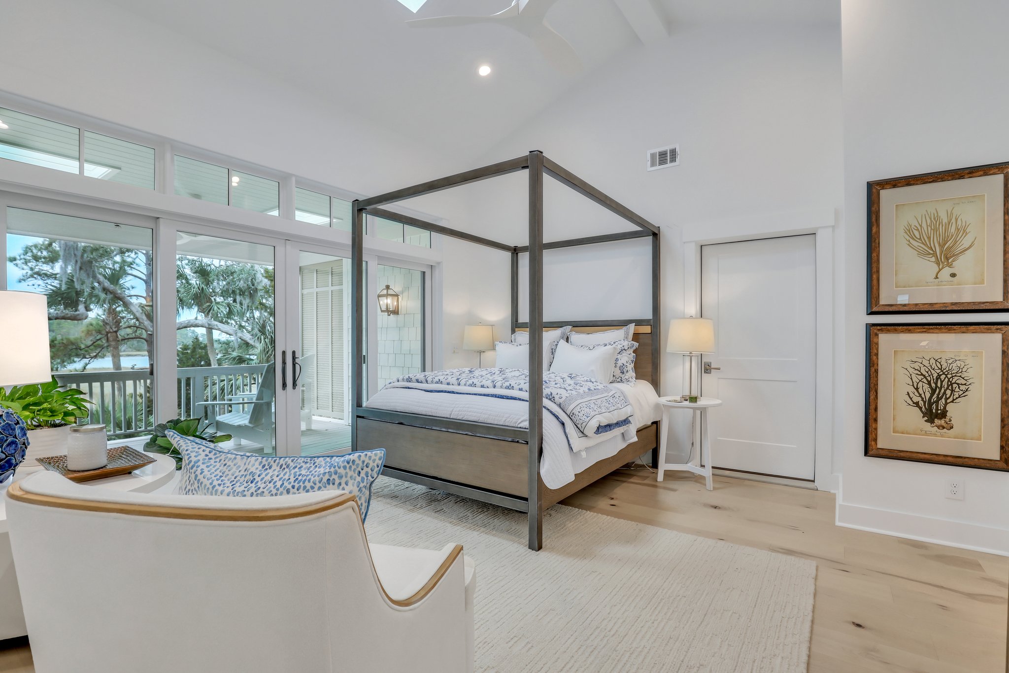 Vaulted ceilings in master bedroom with coastal styling including wide planked, natural wood floors and french doors to deck with marsh views.
