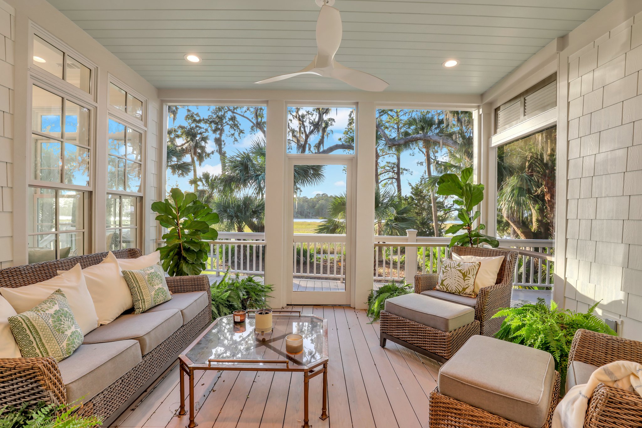 Coastal screened porched with marsh and review views and lightly painted blue ceiling.